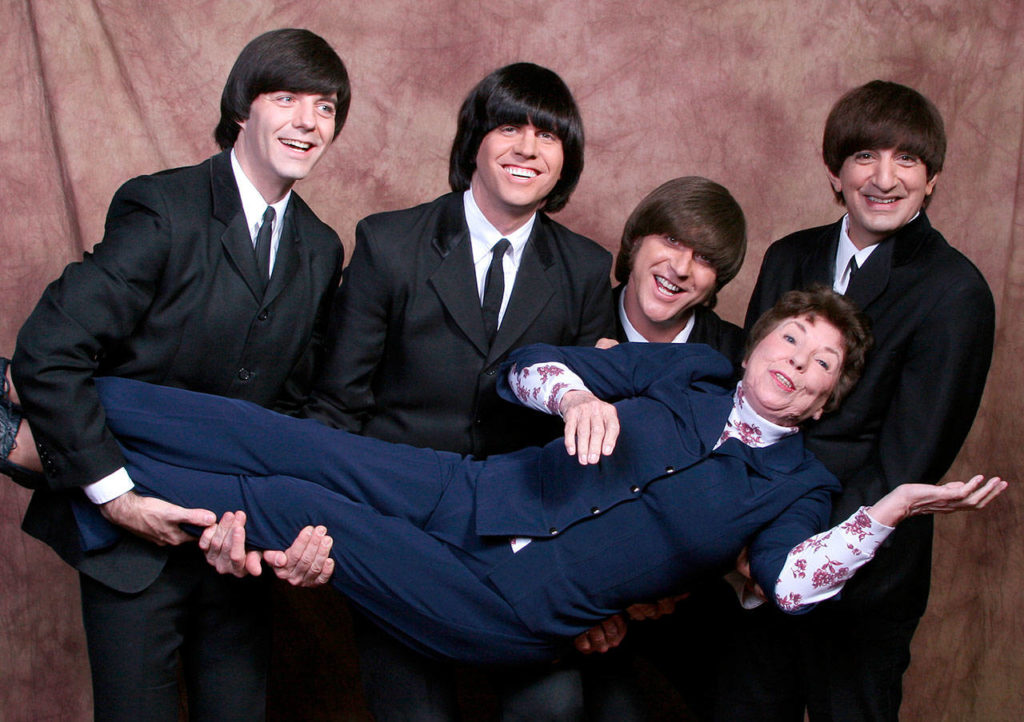 The four members of the Liverpool Legends — David Tanner, Marty Scott, Kevin Mantegna and John Perrin — carry Louise Harrison, George Harrison’s sister. Louise Harrison, 86, handpicked the band members to look, talk and perform like the original Beatles. (Liverpool Legends)
