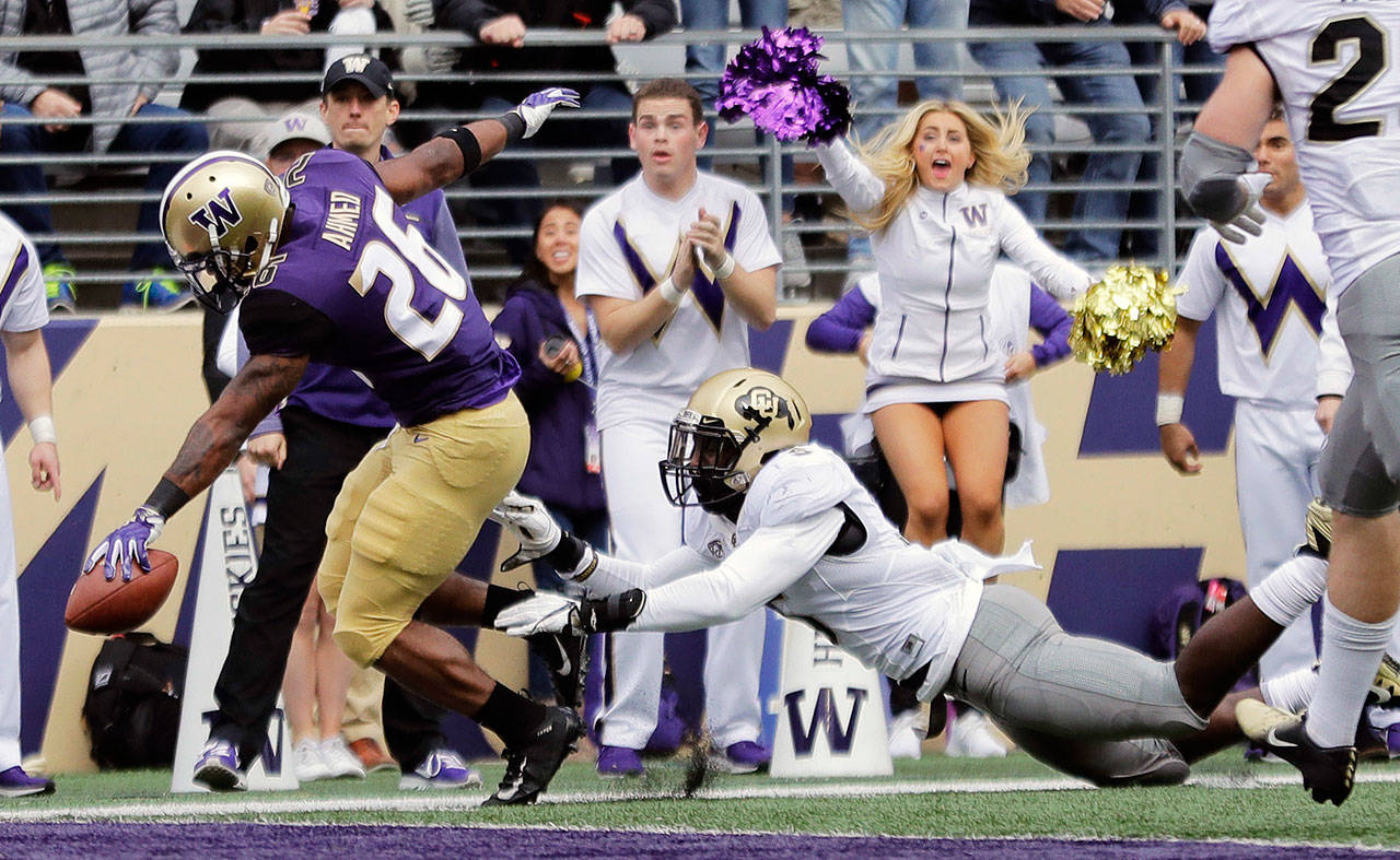 Washington running back Salvon Ahmed (left) scores a touchdown ahead of Colorado linebacker Davion Taylor during the first half of a game on Oct. 20, 2018, in Seattle. (AP Photo/Ted S. Warren)