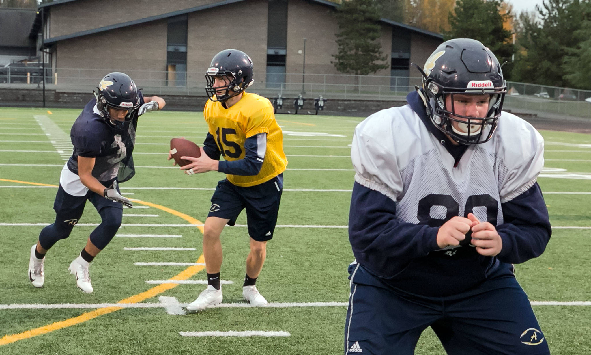 From left to right, Arlington’s Sam Whetstone, Anthony Whitis and Sam Ostap run a play Thursday during a practice session at Arlington High School. (Kevin Clark / The Herald)