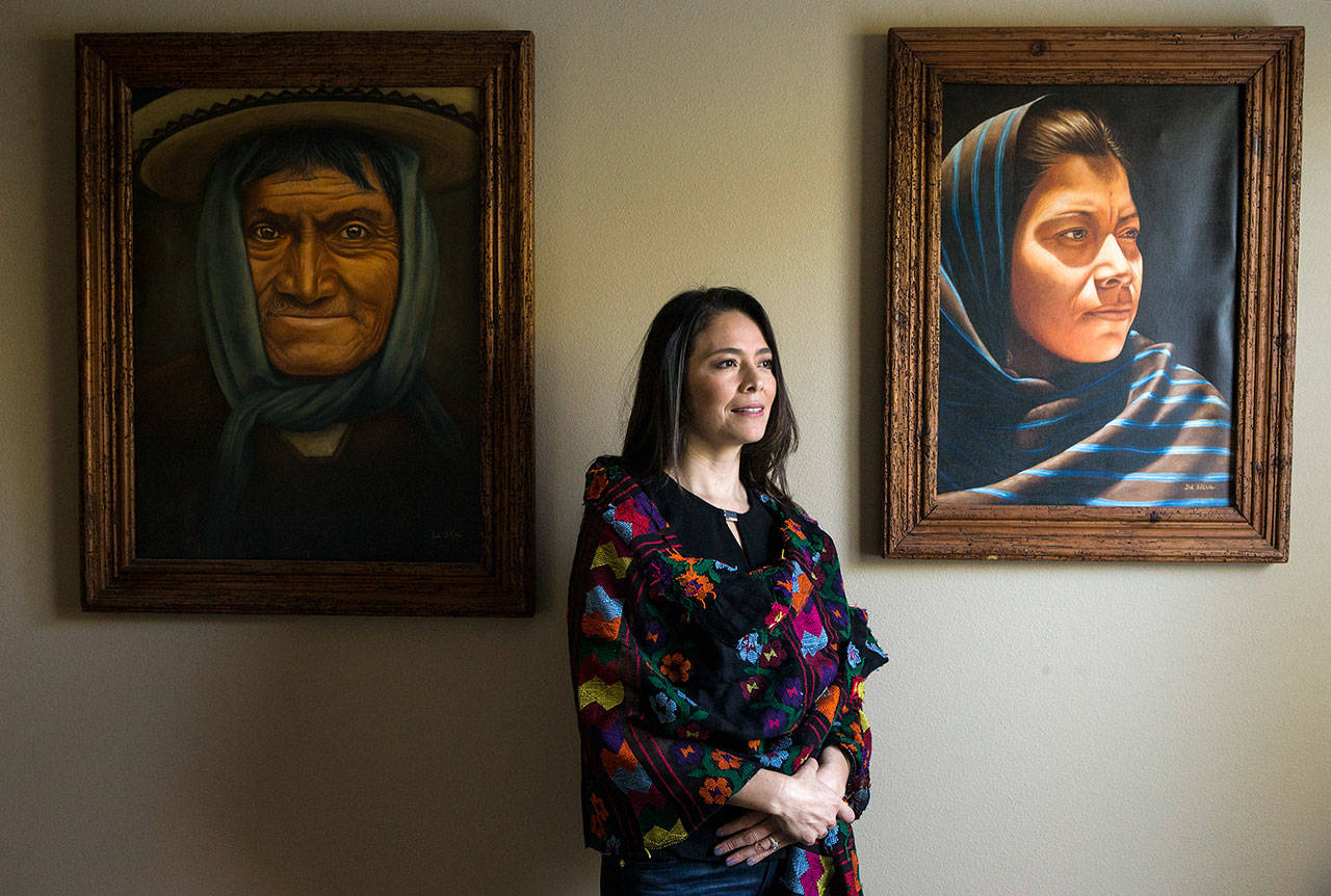 Julieta Altamirano-Crosby at home in Mukilteo with paintings by Morelia, Michoacán artist José Da Silva. She is the founder of the Lynnwood-based WA-GRO Foundation, which helps Latino children maintain their identities and self-confidence through education, culture and the arts. (Andy Bronson / The Herald)