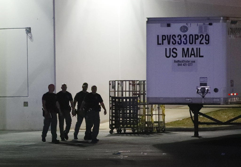 Members of the Miami-Dade County Bomb Squad walk outside a postal facility Thursday in Opa-locka, Florida. (AP Photo/Wilfredo Lee)
