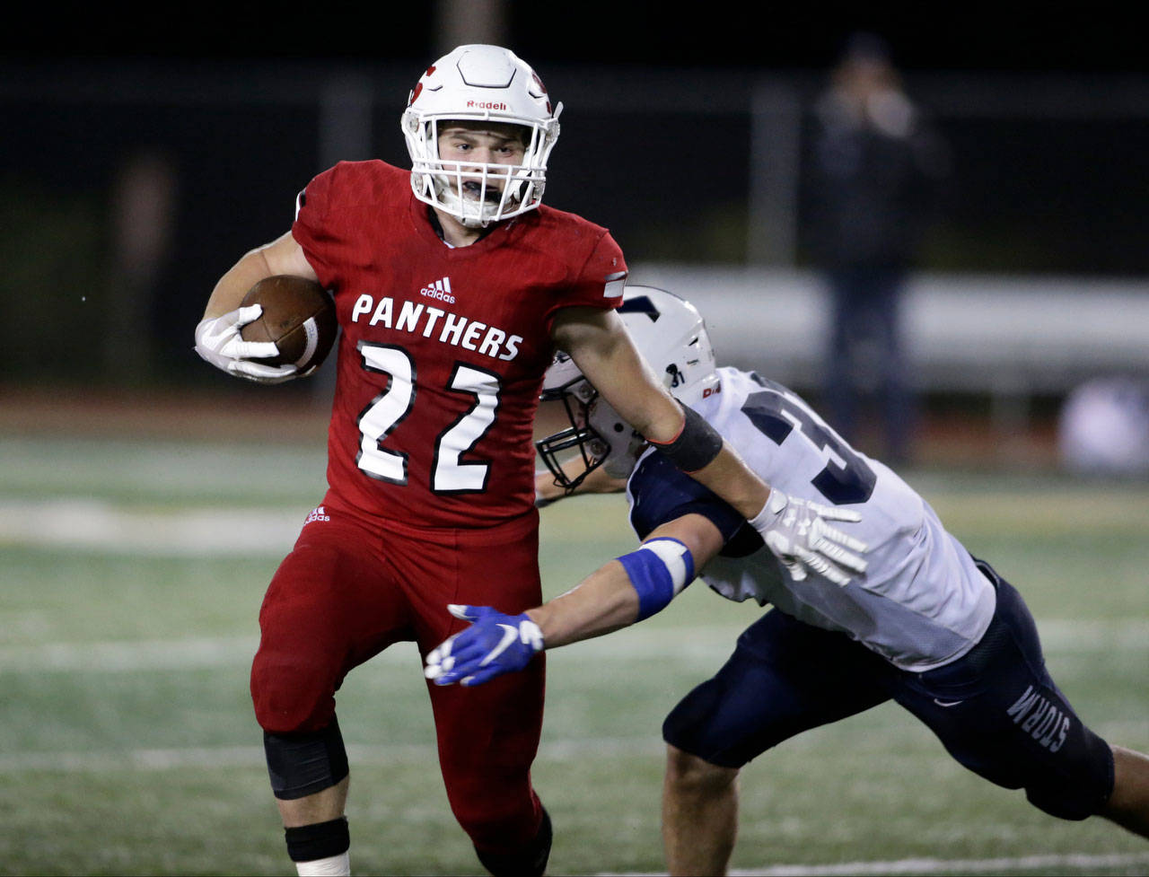Snohomish running back Tyler Larson pushes off an opponent as he fights for yards in the Panthers’ 30-27 Squalicum victory on Friday night at Veterans Memorial Stadium in Snohomish. (Andy Bronson / The Herald)