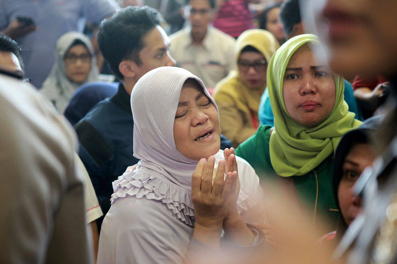 A relative of passengers prays as she and others wait for news on a Lion Air plane that crashed off Java Island at Depati Amir Airport in Pangkal Pinang, Indonesia, on Monday. Indonesia disaster agency says that the Lion Air Boeing 737 MAX 8 plane crashed into sea shortly after it left Indonesia’s capital Monday morning. (AP Photo/Hadi Sutrisno)