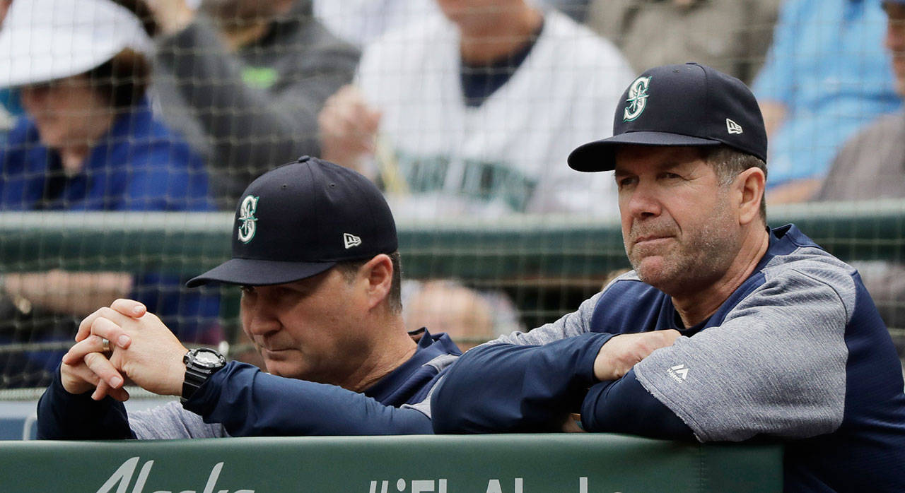 Seattle Mariners hitting coach Edgar Martinez (right) and manager Scott Servais watch from the dugout during a game against the Texas Rangers on May 16, 2018, in Seattle. (AP Photo/Ted S. Warren)