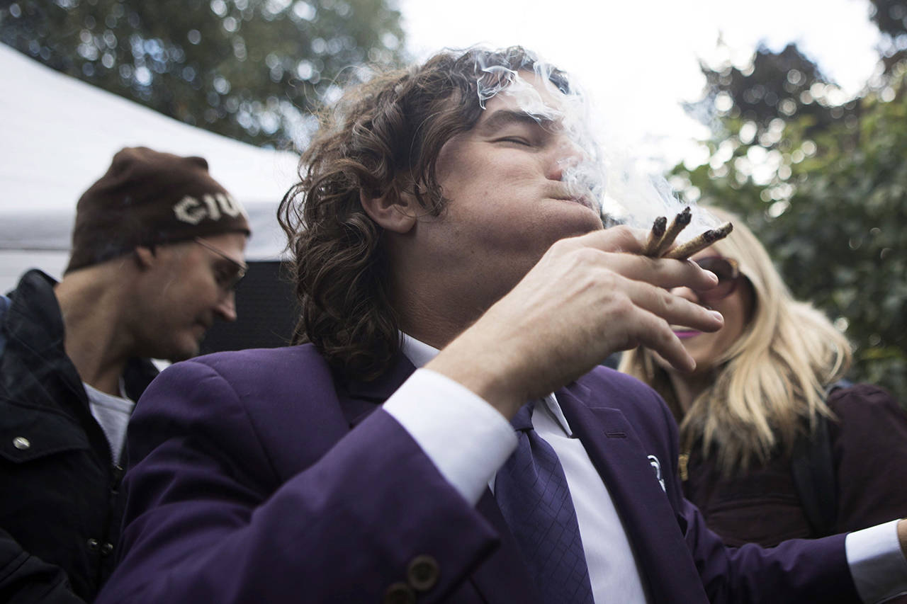 In this Oct. 17 photo, a man smokes multiple joints in a Toronto park as they mark the first day of legalization of cannabis across Canada. Supply shortages have been rampant in the two weeks since Canada became the largest national pot marketplace. (Chris Young/The Canadian Press via AP, File)