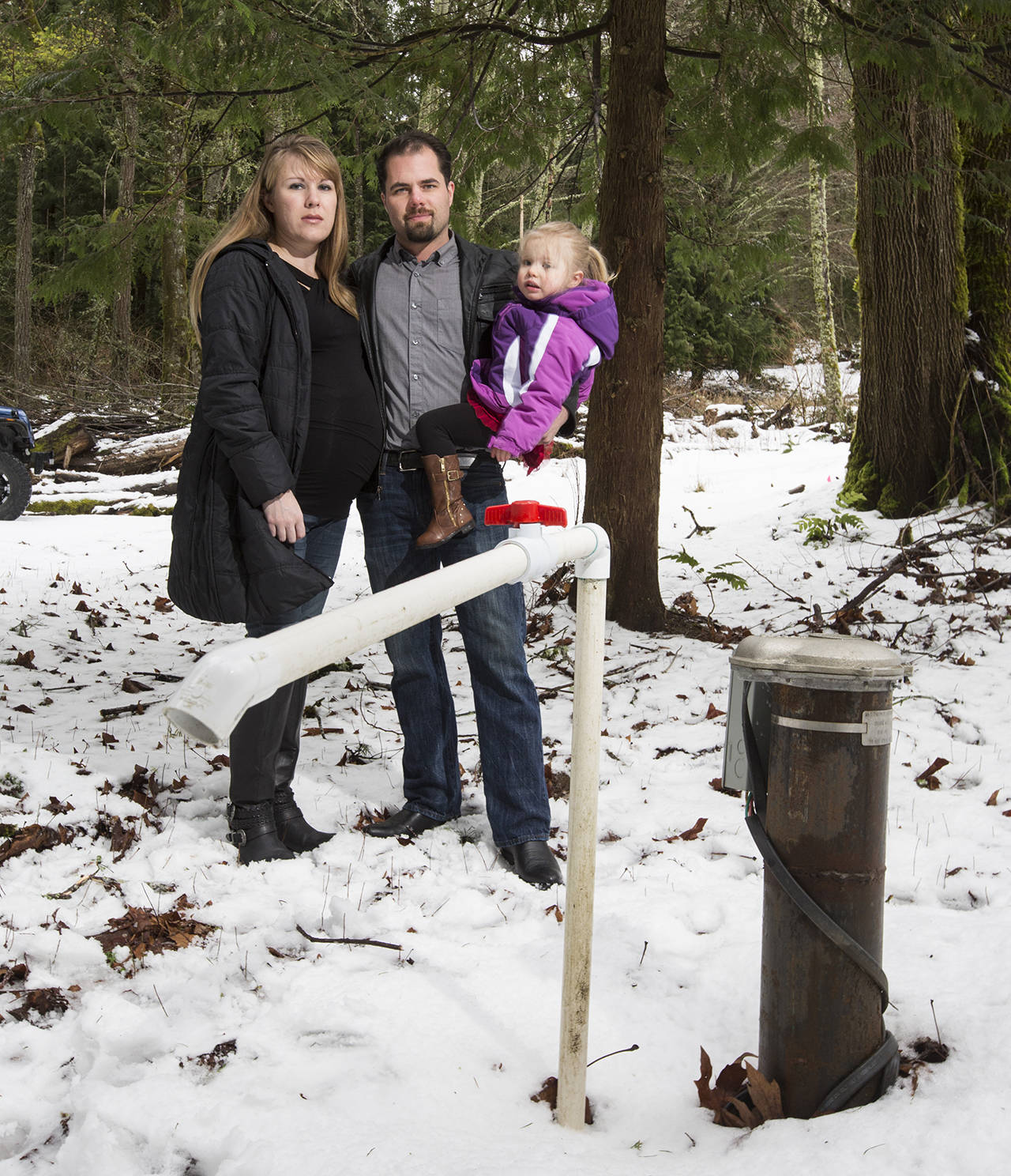 Buddy Breakey and wife Deborah and daughter Kaylin by a well on their new property on Squalicum Mountain Road. (Andy Bronson / The Herald)