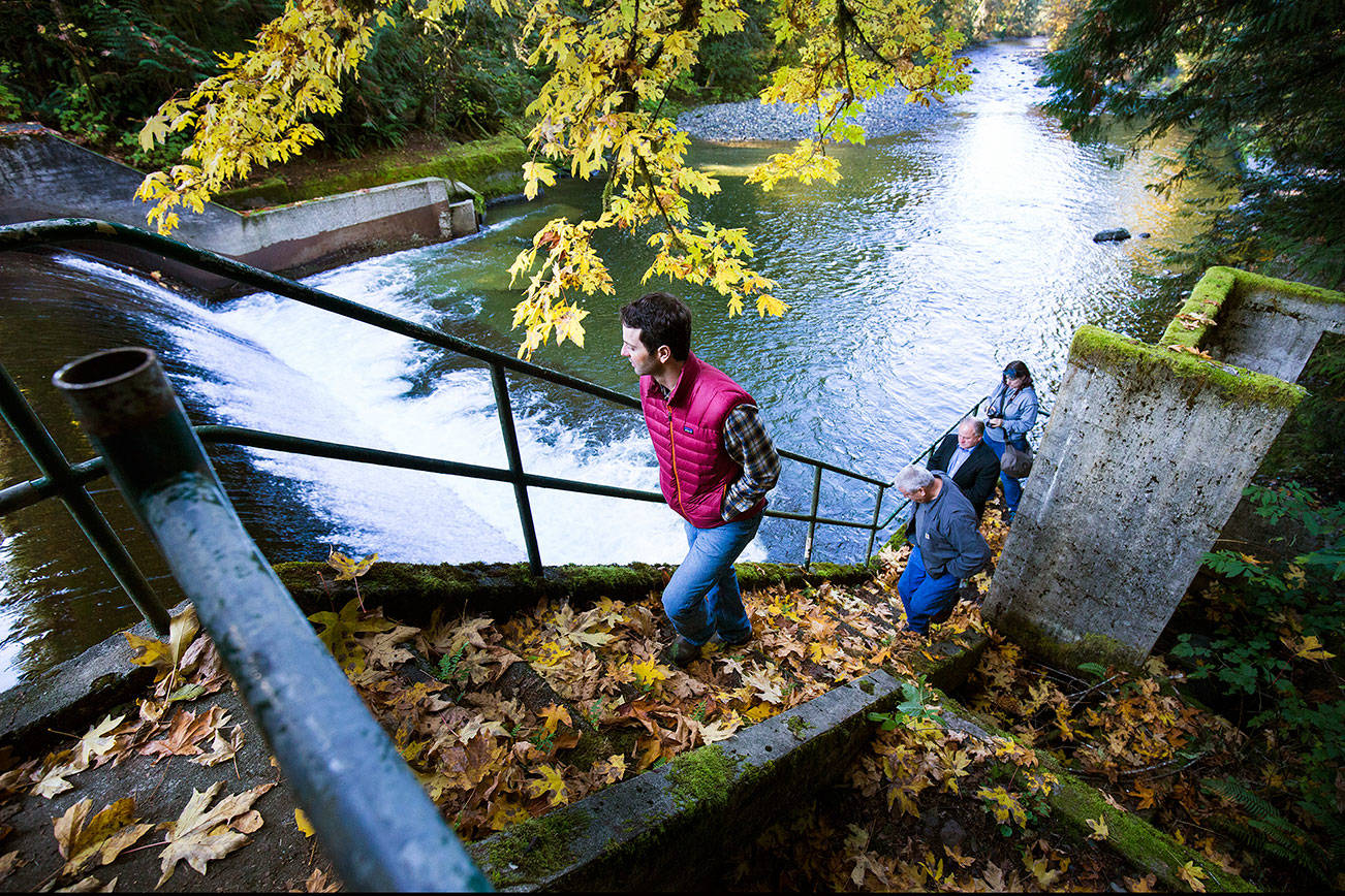 Tulalip Tribes restoration ecologist Brett Shattuck, in red vest, takes a tour up the steps of the Pilchuck Dam along the Pilchuck River on Tuesday, Oct. 16, 2018 in Granite Falls. A joint project by the Tribes and the city of Snohomish intends to remove the dam by the fall of 2020. (Andy Bronson / The Herald)