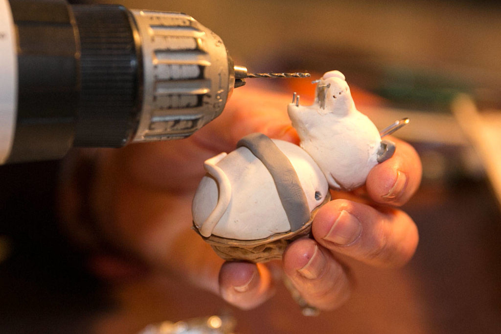 Caralee Hudson works on ornaments at her home. (Kevin Clark / The Herald)
