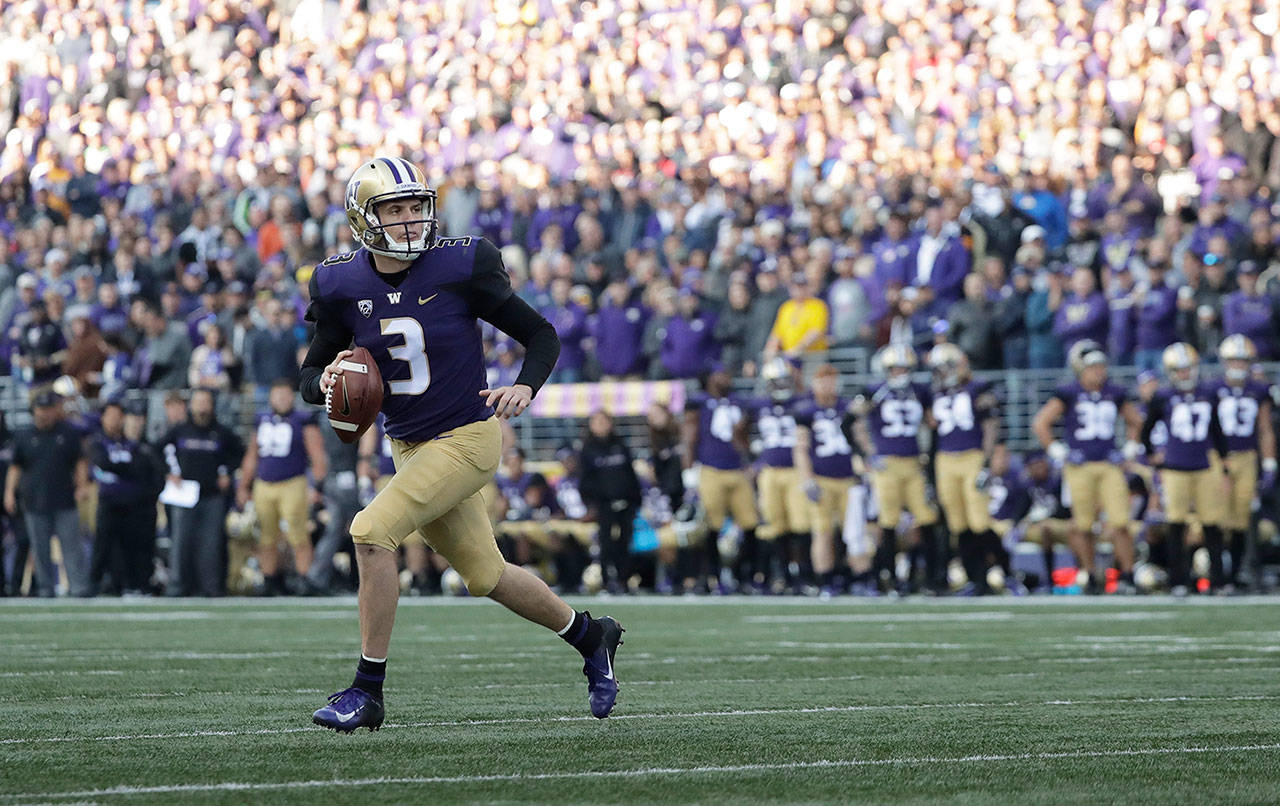 Washington quarterback Jake Browning scrambles to pass against Colorado during a game on Oct. 20 in Seattle. (Ted S. Warren / Associated Press)