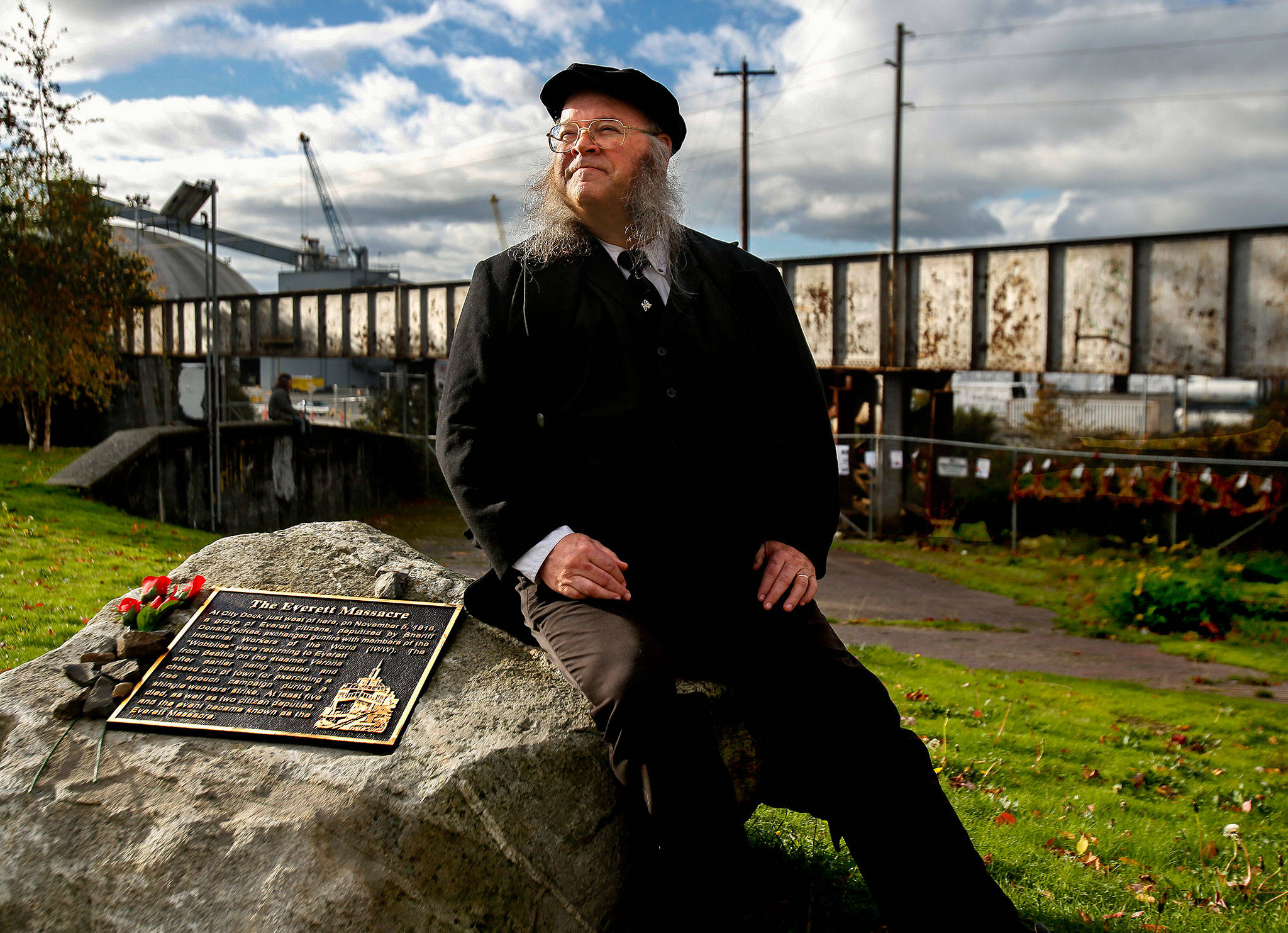 Seated next to the Everett Massacre plaque and dressed with a vintage look, history buff Christopher Summit talks about the events that took place Nov. 5, 1916, from a little different perspective. (Dan Bates / The Herald)