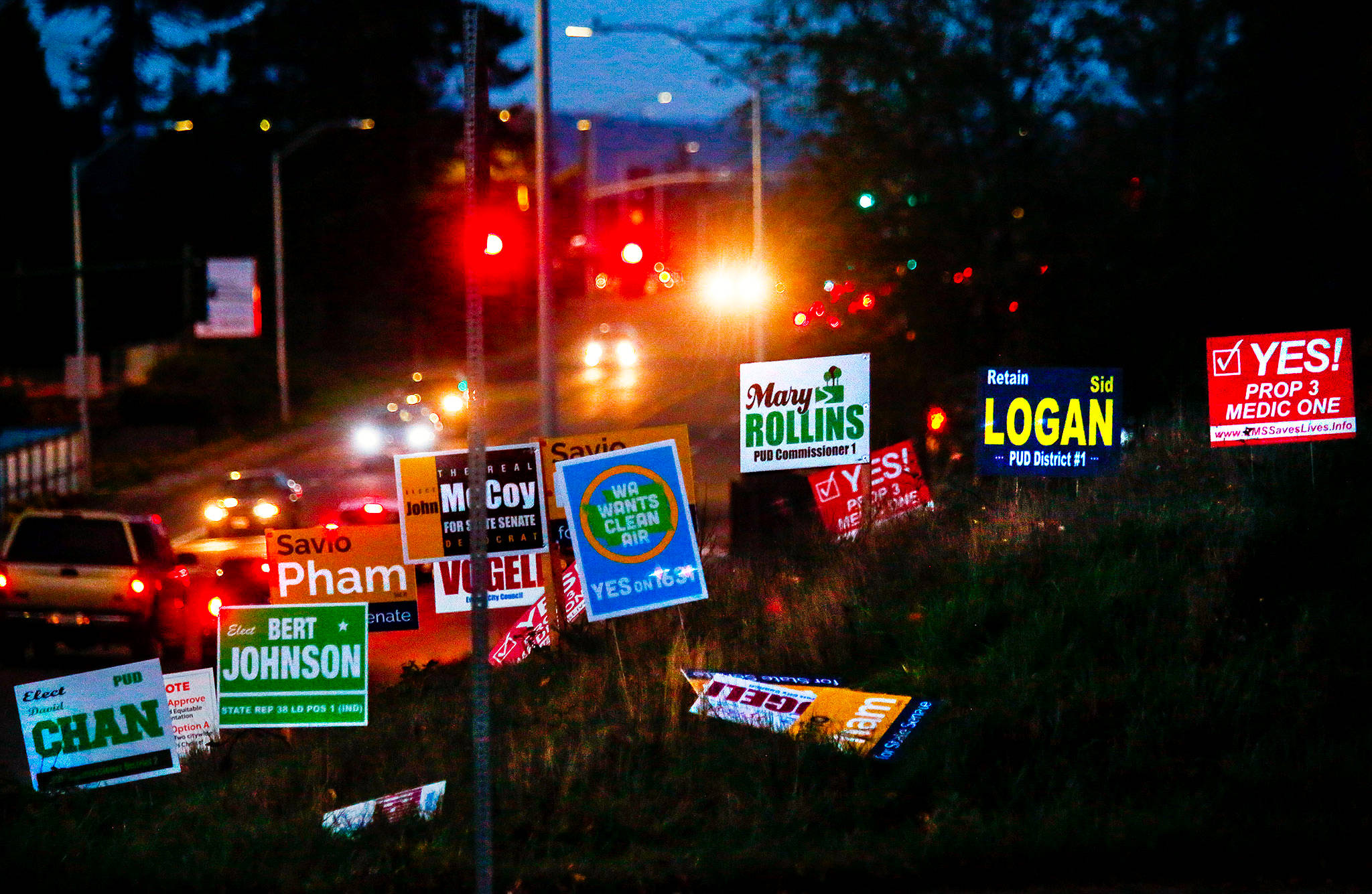 As darkness begins to take over late Wednesday, afternoon commute drivers encounter more than 16 political signs on the northeast corner of Colby Avenue and 44th Street in Everett. (Dan Bates / The Herald)