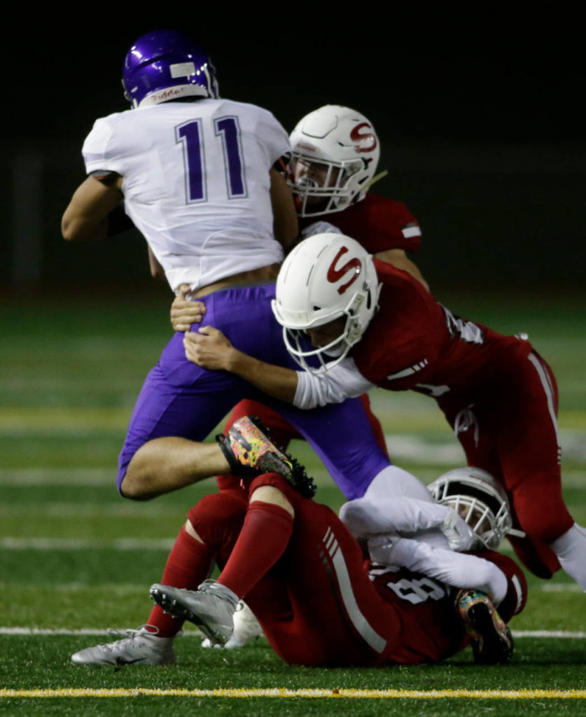 Three Snohomish defenders take down Garfield’s Quinton Jordan during a Week 10 playoff game on Nov. 2, 2018, at Veterans Memorial Stadium in Snohomish. Snohomish won 42-35. (Andy Bronson / The Herald)
