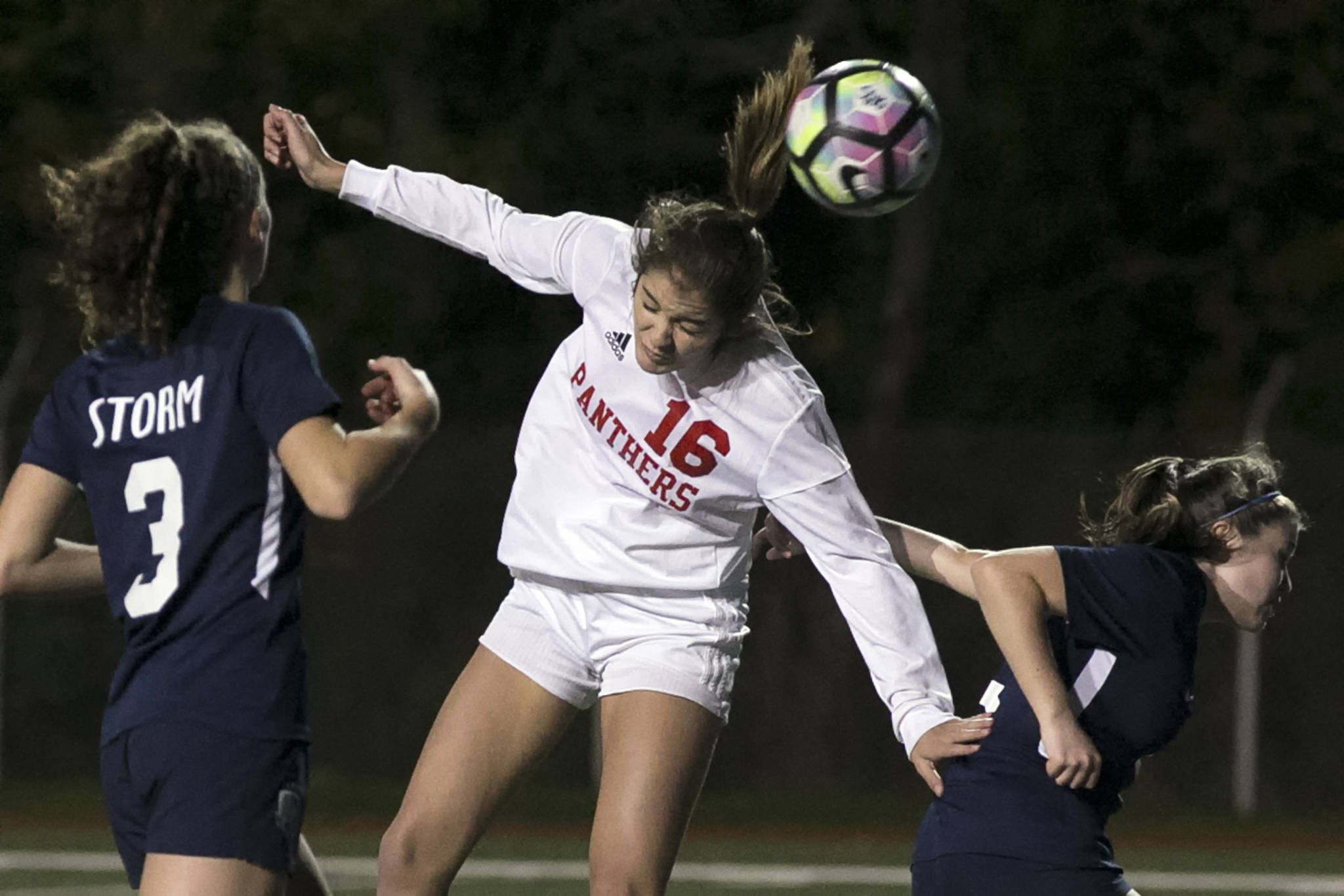 Snohomish’s Taylor Khorrami makes a header for a goal with Squalicum’s Audra Johnson (left) and Jamie Dierdorf defending during the NW District 1 3A Soccer Tournament at Shoreline Stadium on Oct. 30. (Kevin Clark / The Herald)