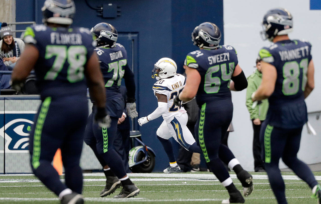 Seahawks players watch from a distance as Chargers defensive back Desmond King II returns a fourth-quarter interception for a touchdown Sunday at CenturyLink Field. (AP Photo/Ted S. Warren)