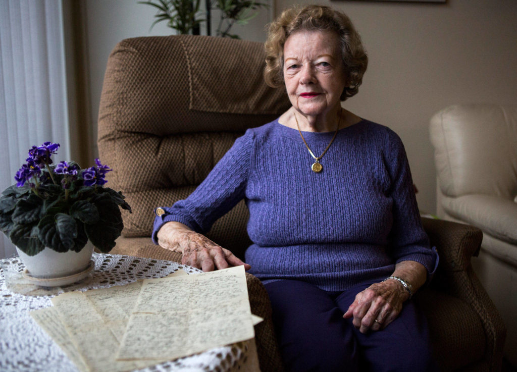 Elaine Reas, 87, with a handful of 100-year-old letters written by her father during World War I, at her home in Lynnwood on Friday. (Olivia Vanni / The Herald)
