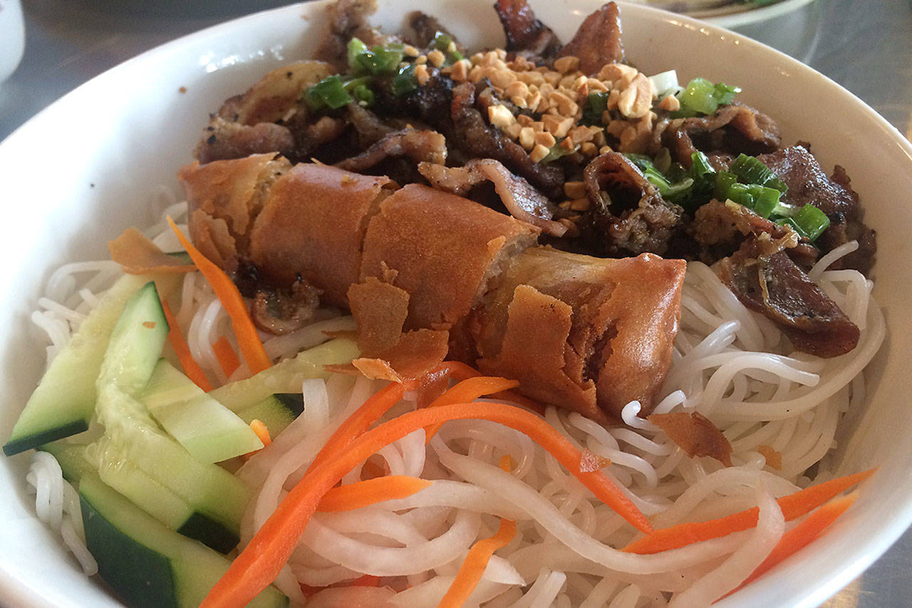 A grilled pork and noodle dish with fried egg rolls, cucumbers, pickled carrots, roasted peanuts, cucumbers and nuoc mam, a fish sauce, at Basil in south Everett. (Evan Thompson / The Herald)                                Basil, a new Vietnamese restaurant in Everett, serves a grilled pork and noodle dish with fried egg rolls, cucumbers, pickled carrots, roasted peanuts, cucumbers and nuoc mam, a fish sauce. (Evan Thompson / The Herald)