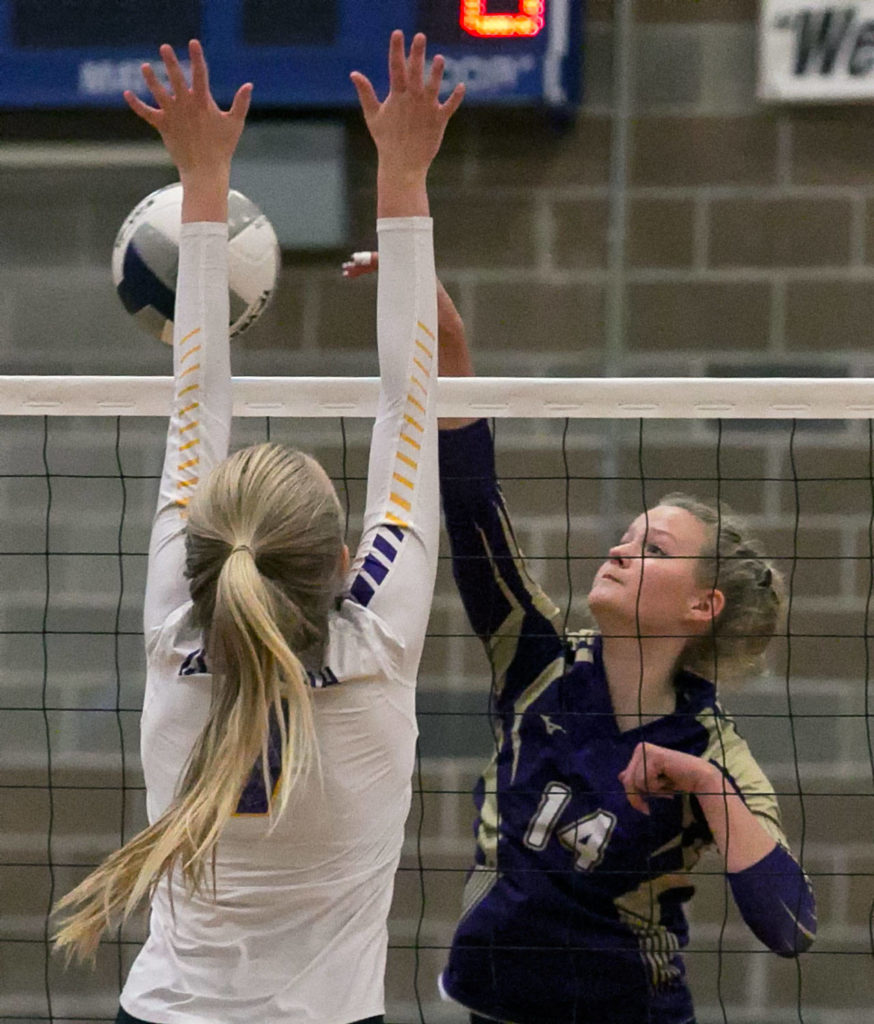 Lake Stevens’ Maddie Iseminger spikes the ball with Issaquah’s Sidney Cottrell (left) defending during the Wes-King 4A District Tournament on Nov. 6, 2018, at Bothell High School. (Kevin Clark / The Herald)

