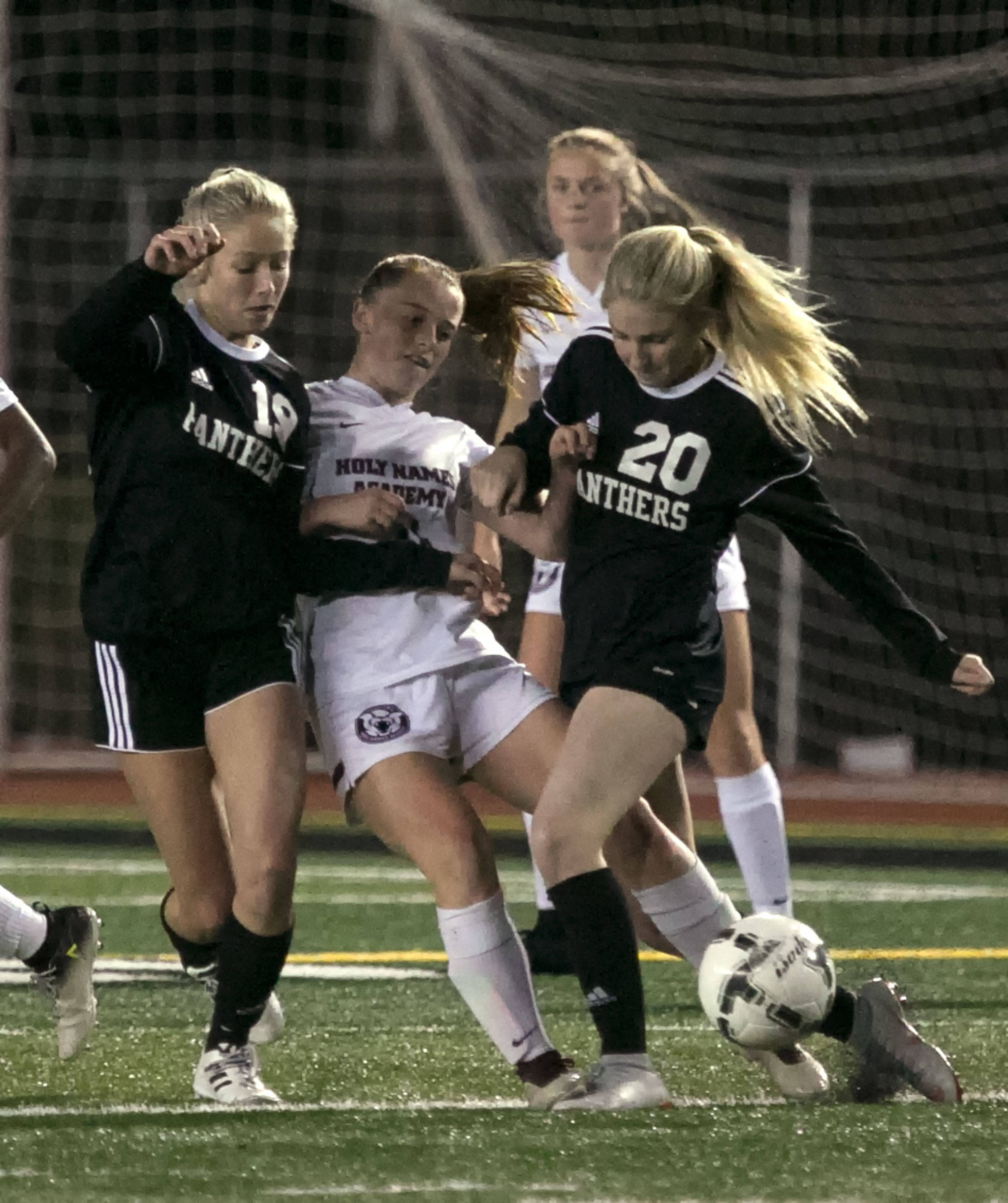 Snohomish’s Gracie Winders (left) and Jenna Schuler (right) crowd Holy Names Academy’s Hannah Gray (center) off the ball during a 3A State Tournament first-round match Wednesday at Veterans Memorial Stadium in Snohomish. (Kevin Clark / The Herald)