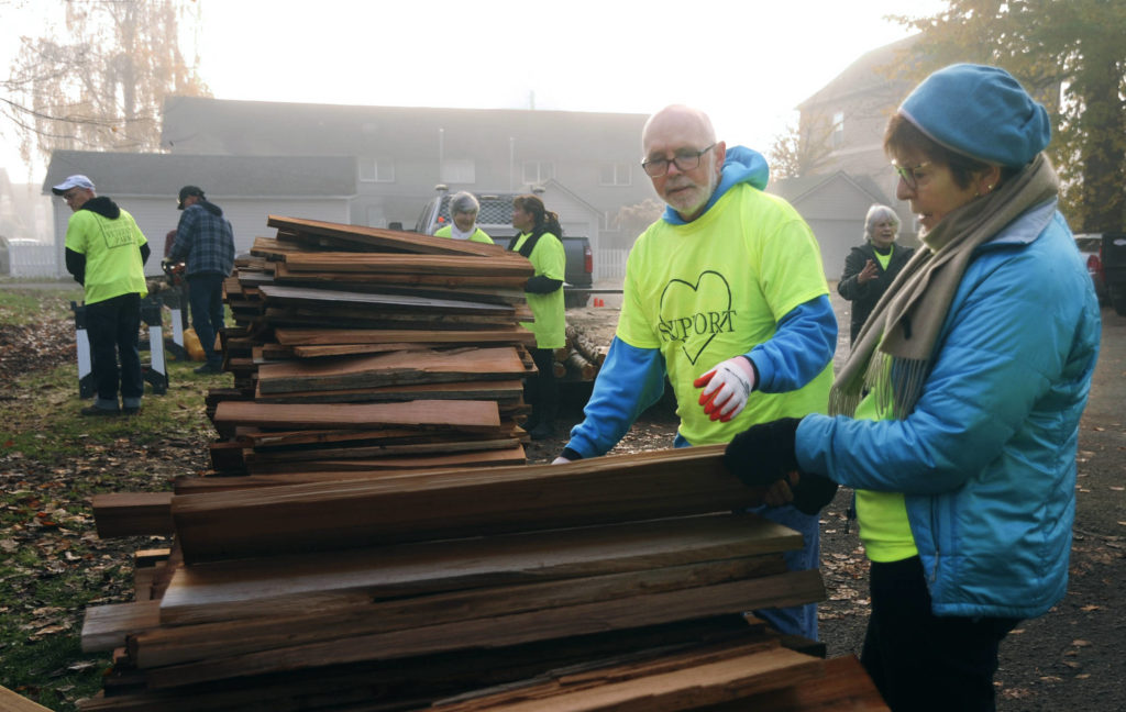 Snohomish Carnegie Foundation Board Members Mac Bates (left) and Clara Granger search for the flattest of cedar shingles to be used as they and other foundation members tackle the job of replacing the shelter roof over the 1940 Lervick log that has been on display in front of the Carnegie library building on Saturday. (Doug Ramsay / For The Herald)
