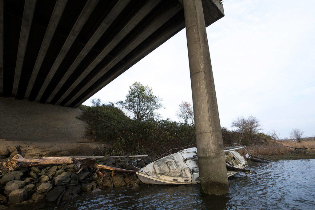 A storm pushed this sailboat downriver three miles where it grounded under the I-5 bridge Tuesday, Nov. 13 in Everett. (Andy Bronson / The Herald)
