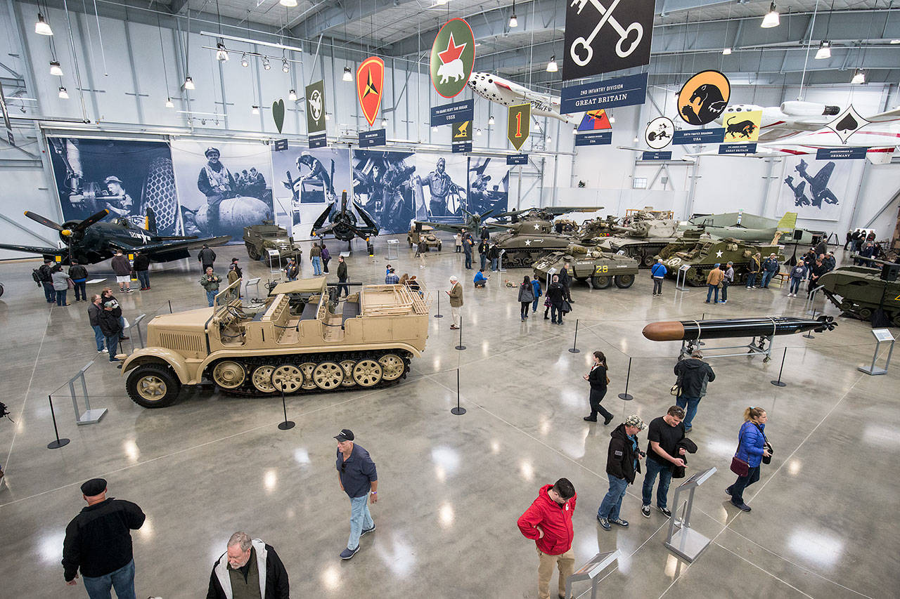 Visitors admire the tanks and planes in the new 30,000-square-foot hangar at the Flying Heritage & Combat Armor Museum at Paine Field on Saturday, Nov. 10, 2018 in Everett. (Andy Bronson / The Herald)