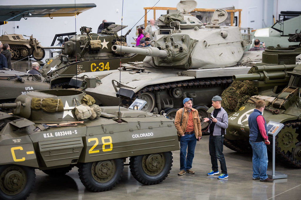 Visitors talk between a half-dozen tanks in the new hangar at the Flying Heritage & Combat Armor Museum at Paine Field on Saturday, Nov. 10, 2018 in Everett. (Andy Bronson / The Herald)

