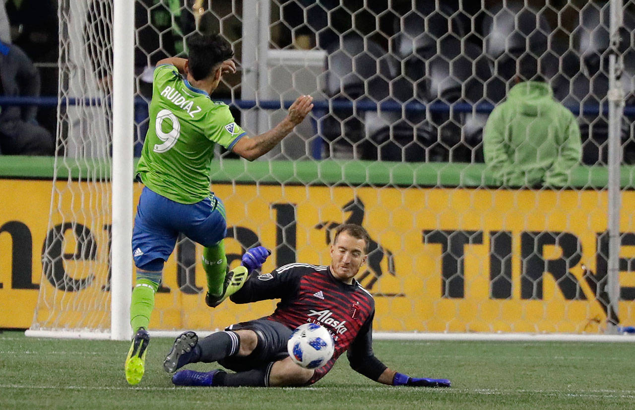 Seattle’s Raul Ruidiaz has a shot deflected by Portland’s Jeff Attinella during the first half of the second leg of an MLS playoff soccer series Thursday in Seattle. (AP Photo/Ted S. Warren)