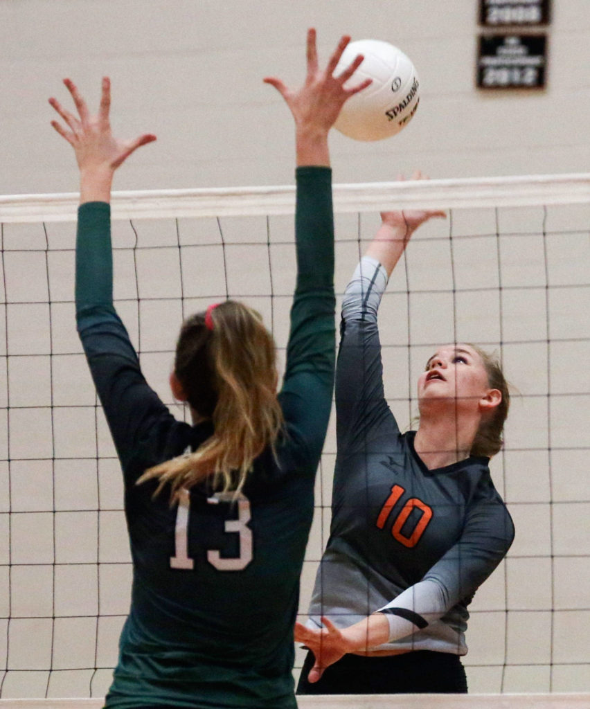 Monroe’s Tatum McGovern (right) attempts a kill over Jackson’s Ainsley Johanson during an Oct. 9 match at Monroe High School. (Kevin Clark / The Herald)
