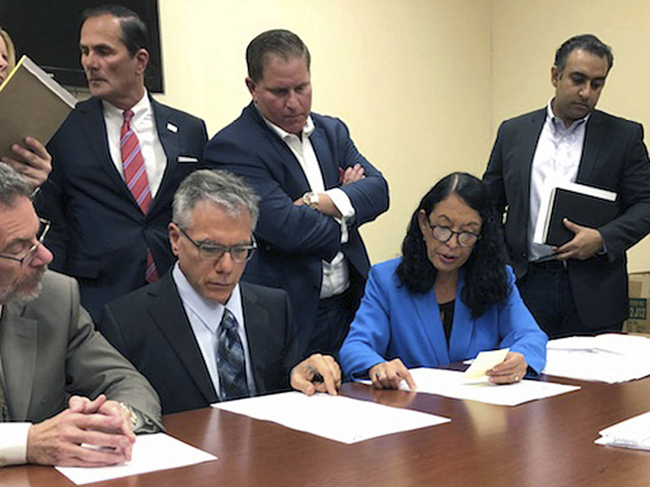 Susan Bucher (second right), Palm Beach County Supervisor of Elections, and Judge August Bonavita (seated at center left) look at provisional ballots in Riviera Beach, Florida, on Friday. A possible recount looms in a tight Florida gubernatorial, U.S. Senate and agriculture commission race. (AP Photo/Josh Repogle)