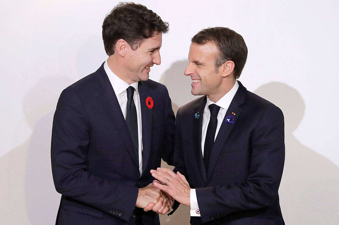 French President Emmanuel Macron (right) meets Canadian Prime Minister Justin Trudeau at the Paris Peace Forum in Paris on Sunday. (Associated Press)