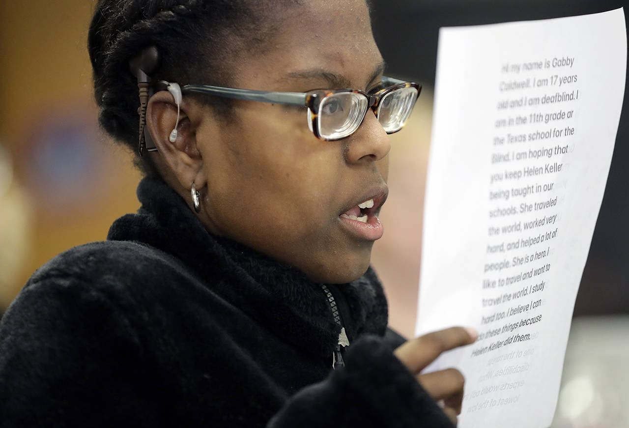 Gabrielle Caldwell, who is partially deaf and blind, looks over her notes where she testified before the Texas School Board during public testimony as they prepares to vote on history curriculum Tuesday in Austin, Texas. (AP Photo/Eric Gay)