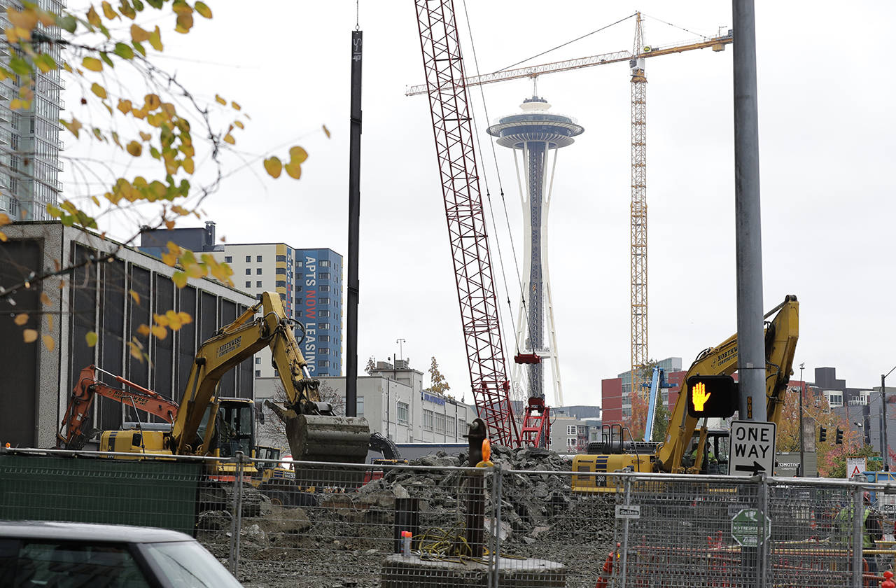 The Space Needle is seen behind a construction project near the Amazon Spheres in downtown Seattle. As Amazon turns its attention to setting up new homes in Long Island City in New York and Arlington, Virginia, experts and historians in Seattle say both places can expect a delicate relationship with the world’s hottest online retailer. (AP Photo/Ted S. Warren)