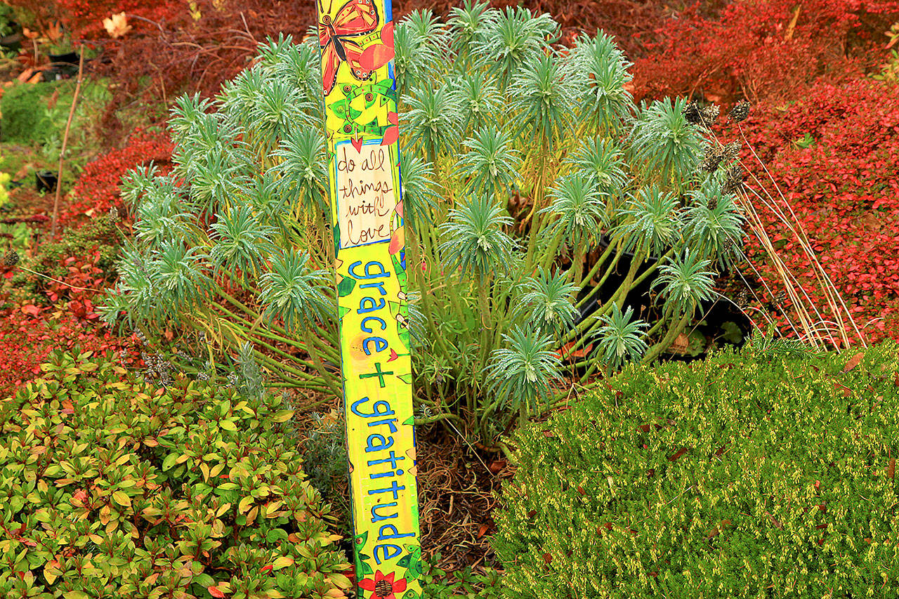 The author is greeted by messages written on a pole in her garden that remind her to have “grace and gratitude” and to “do all things with love.” The garden art was created by local artist Stephanie Burgess. (Pam Roy)