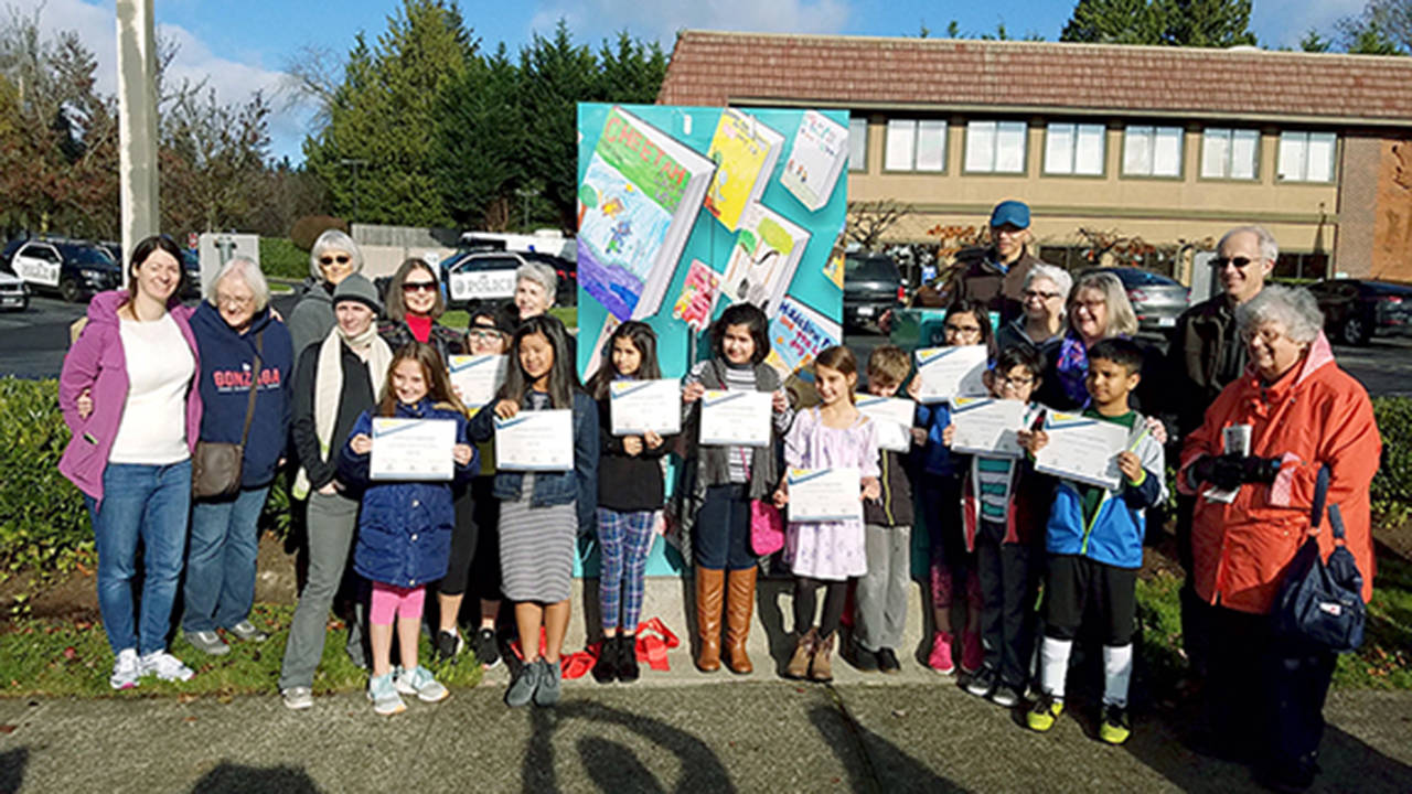 Students and library boosters took part in a ribbon cutting Nov. 10 for the latest signal box wrap, “Libraries Are For Everyone!”, at the northeast corner of 194th Street and 44th Avenue outside the Lynnwood Police Station. (Contributed photo)
