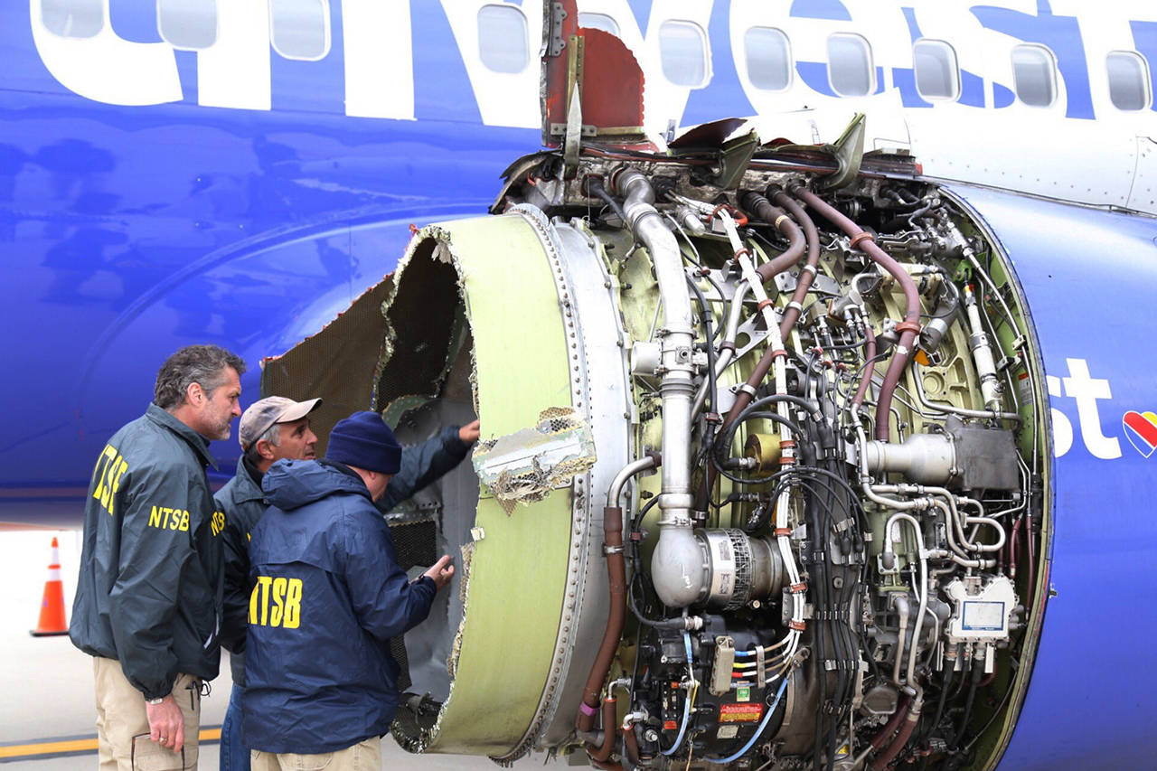 In this April 17 photo, National Transportation Safety Board investigators examine damage to the engine of the Southwest Airlines plane that made an emergency landing at Philadelphia International Airport in Philadelphia. (NTSB via AP, file)