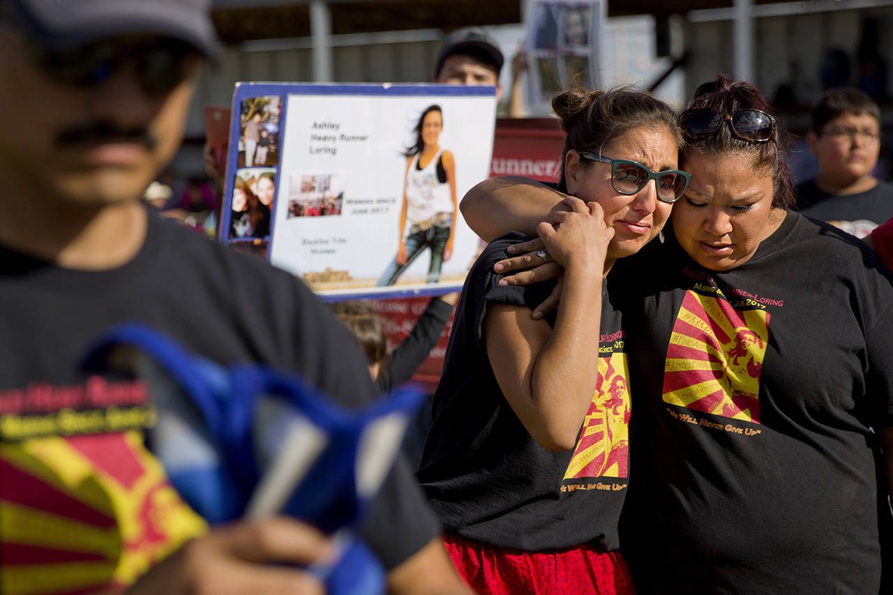 In this July 14 photo, Jenna Loring (left), the aunt of Ashley HeavyRunner Loring, cries with her cousin, Lissa Loring, during a traditional blanket dance before the crowd at the North American Indian Days celebration on the Blackfeet Indian Reservation in Browning, Montana. (AP Photo/David Goldman, File)