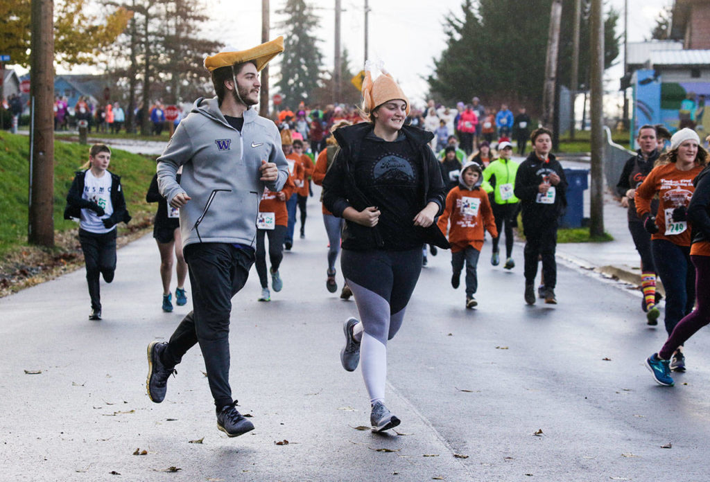  Danielle Guenther, of Bothell, runs with her husky Rhodey at the Turkey Trot 5K on Thursday in Arlington. (Andy Bronson / The Herald)
 A couple sports pumpkin pie and turkey hats as they run in the Turkey Trot 5K on Thursday in Arlington. (Andy Bronson / The Herald)
A couple sports pumpkin pie and turkey hats as they run in the Turkey Trot 5K on Thursday in Arlington. (Andy Bronson / The Herald)
