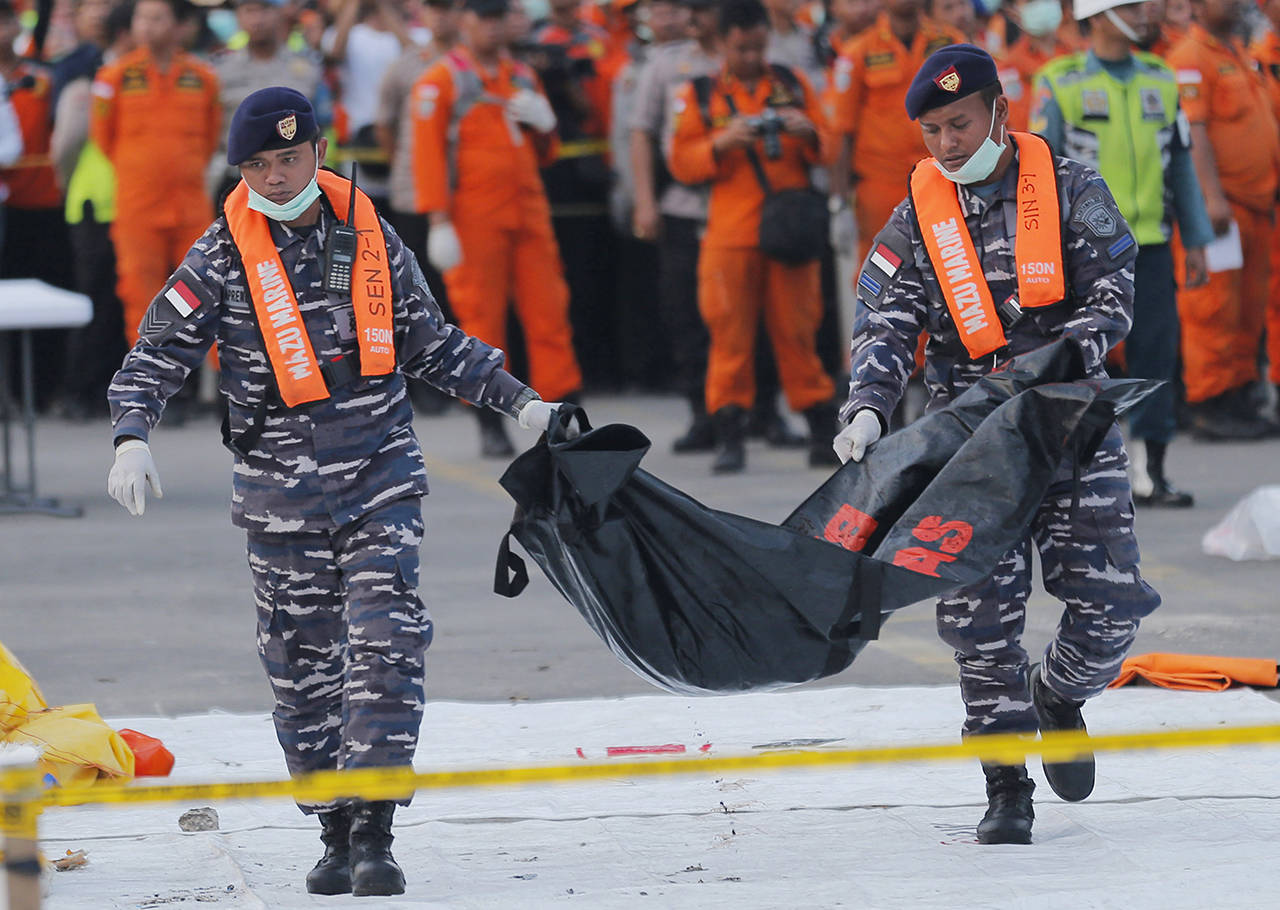 On Nov. 1, Navy personnel carry the remains of a victim of Lion Air jet that crashed into the sea at the Tanjung Priok Port in Jakarta, Indonesia. (AP Photo/Tatan Syuflana, File)
