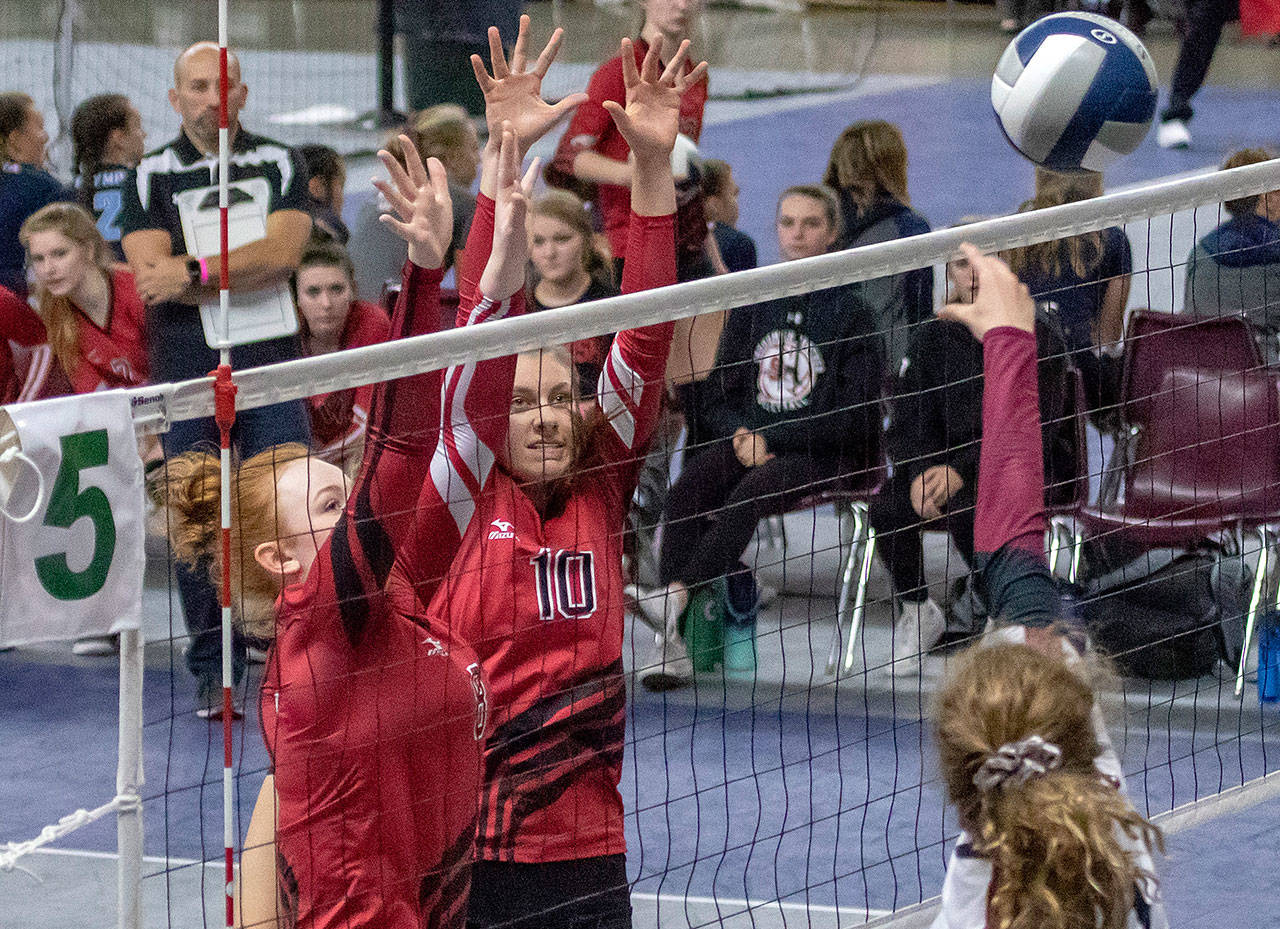Snohomish’s Sarah Campfield (10) and Grace Raper (8) jump to block Prairie’s Maddie Cederholm (9) during a 3A state consolation match on Nov. 17, 2018, at the Yakima Valley SunDome in Yakima. (TJ Mullinax / For The Herald)
