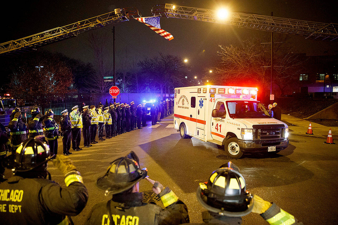 Police and firefighters salute as an ambulance arrives at the medical examiner’s office carrying the body of Chicago Police Department Officer Samuel Jimenez, who was killed during a shooting at Mercy Hospital earlier in the day Monday. (Armando L. Sanchez/Chicago Tribune via AP)
