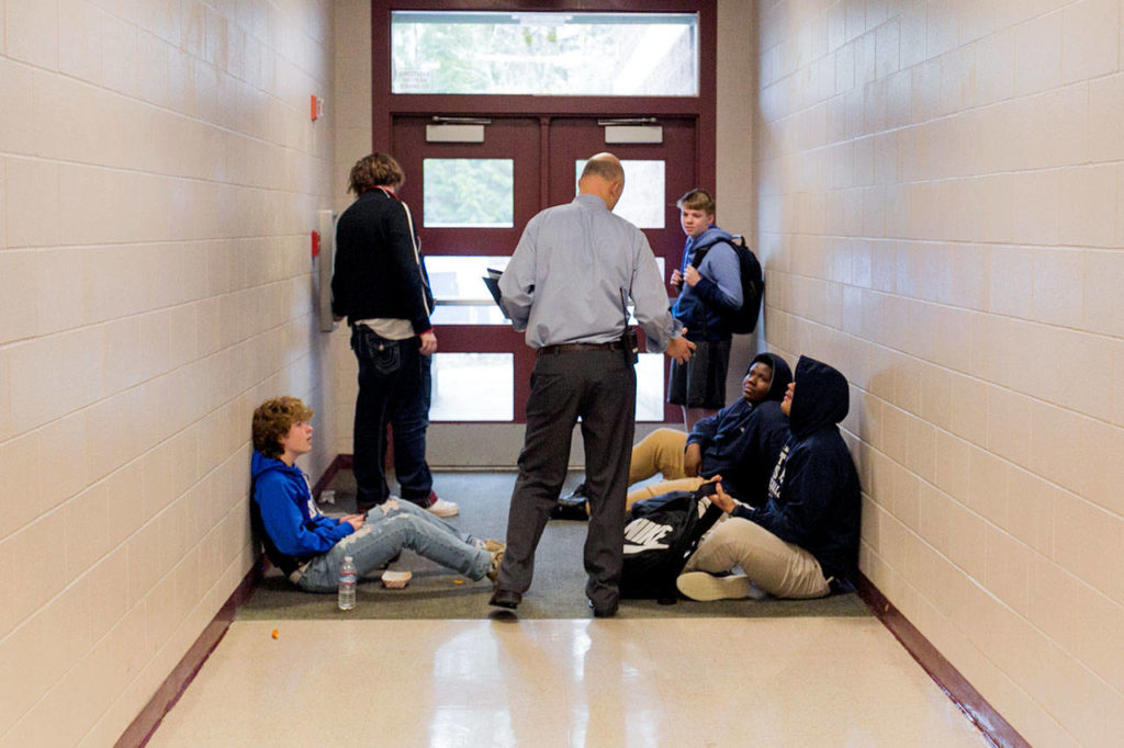 Principal Dave Peters holds the door for students exiting first lunch Monday morning at Henry M. Jackson High School in Mill Creek on Jan. 22. (Kevin Clark / The Daily Herald)
