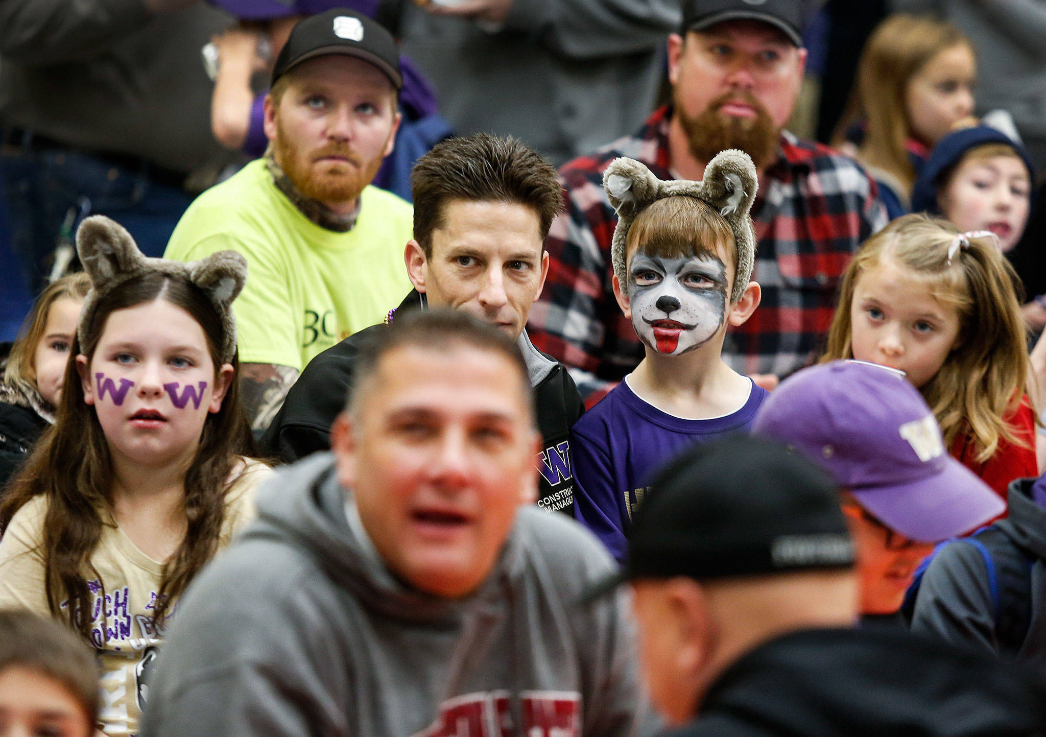 Finn Ottele (center right) and Mady Ottele (left) sport Washington Huskies face paint at Dutch Hill Elementary’s Apple Cup-themed Dads ‘n Donuts event, with the gym decked out in Cougar and Husky colors, on Nov. 21, 2018, in Snohomish. (Andy Bronson / The Herald)