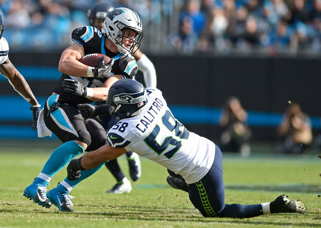 Carolina running back Christian McCaffrey (22) is stopped by Seattle linebacker Austin Calitro (58) during the first half of their game Sunday in Charlotte, North Carolina. (AP Photo/Mike McCarn)