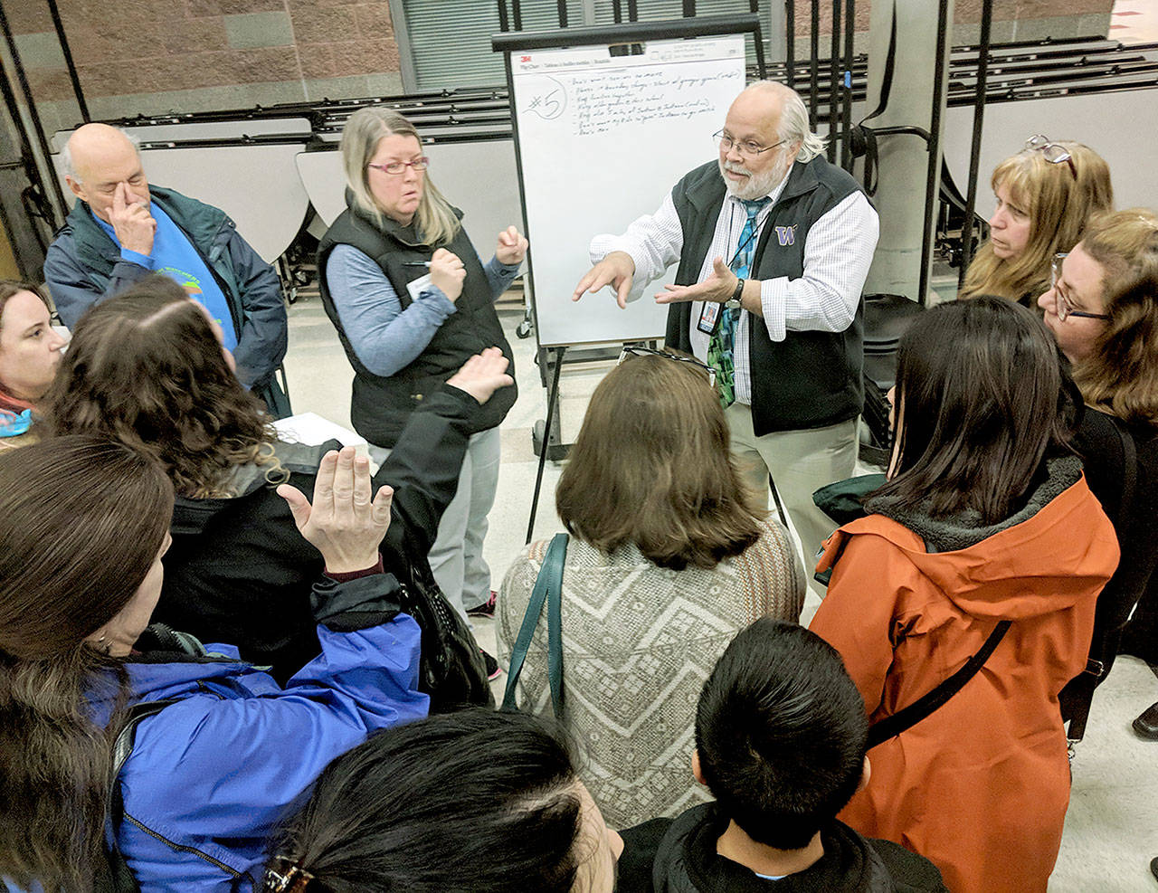 Everett School District administrator Gerard Holzman talks with parents on Tuesday at Henry M. Jackson High School about new boundary lines. (Zachariah Bryan / The Herald)