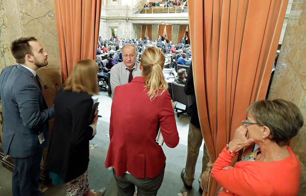 House Speaker Frank Chopp (third from left), D-Seattle, huddles with legislative staffers in the wings of the House last March. (AP Photo/Ted S. Warren) 
