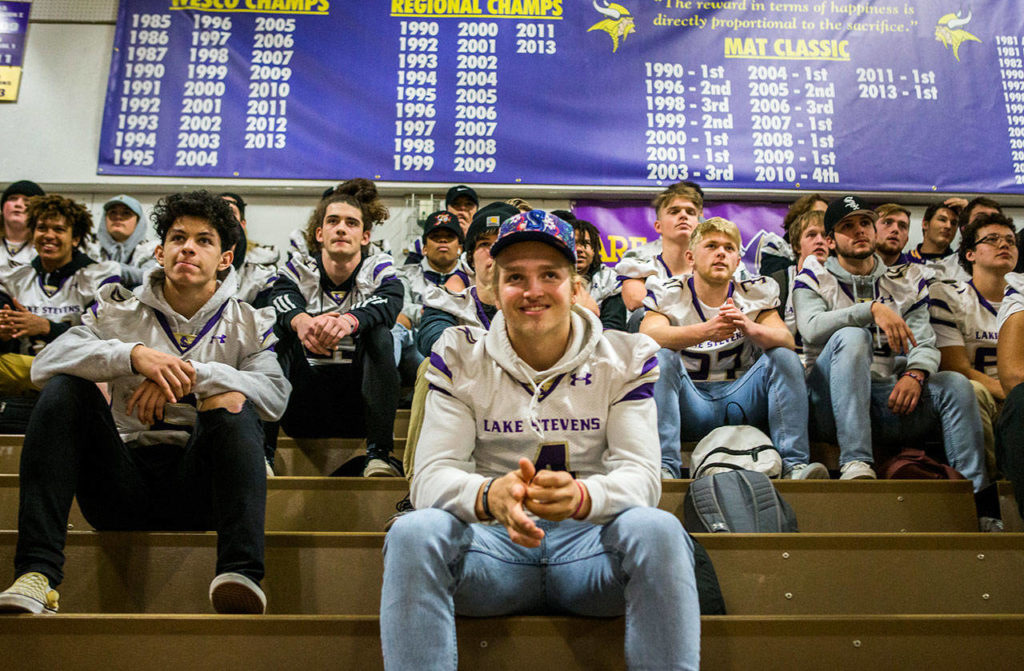 Lake Stevens’ quarterback Tre Long (center) smiles as the team watches a highlight video during the pep rally send-off for the football team Friday in Lake Stevens. (Olivia Vanni / The Herald)
