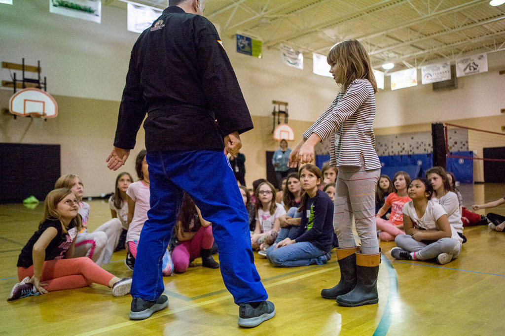 Girls watch as they are taught defense moves during an InspireHER event at the Snohomish Boys & Girls Club. (Olivia Vanni / The Herald) 
