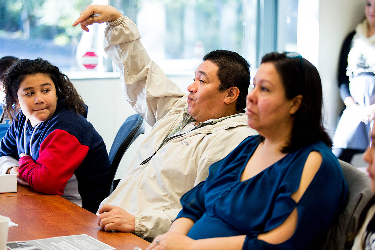 Roberto Galeana asks a questions as he, his wife and their five children take part in the Parent Leadership Training Institute and the Children’s Leadership Institute on Saturday, Nov. 17, 2018 in Everett, Wa. At left is son Robert Galeana and wife Blanca, right. (Andy Bronson / The Herald)
