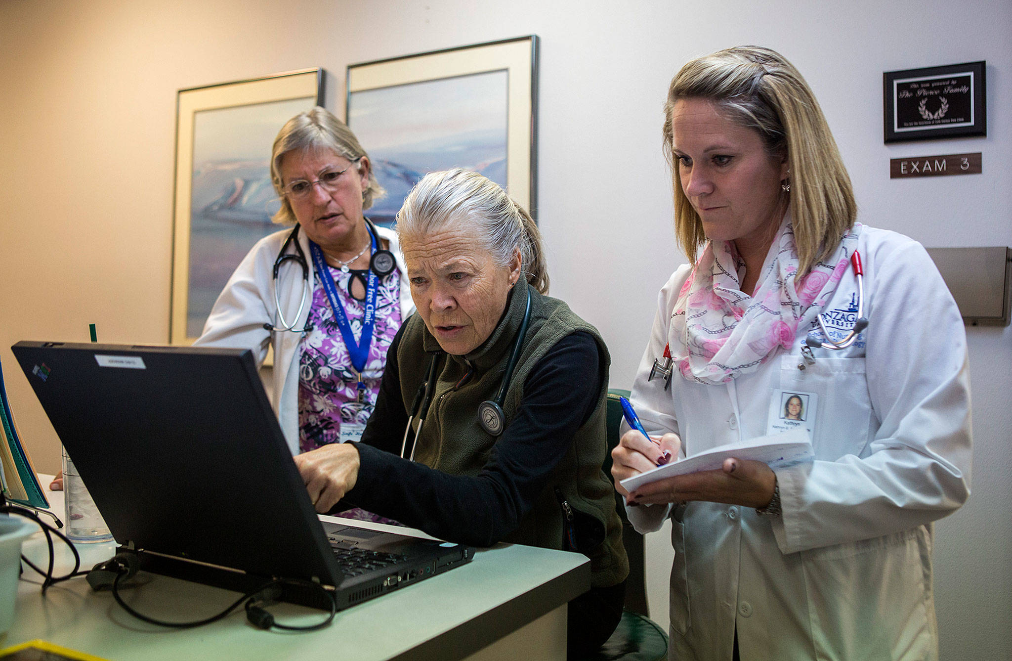 Cathy Fliris (left), Colleen Shannon (center) and Kathryn Arneson look over test results of a patient at the Safe Harbor Clinic in Stanwood. (Olivia Vanni / The Herald)