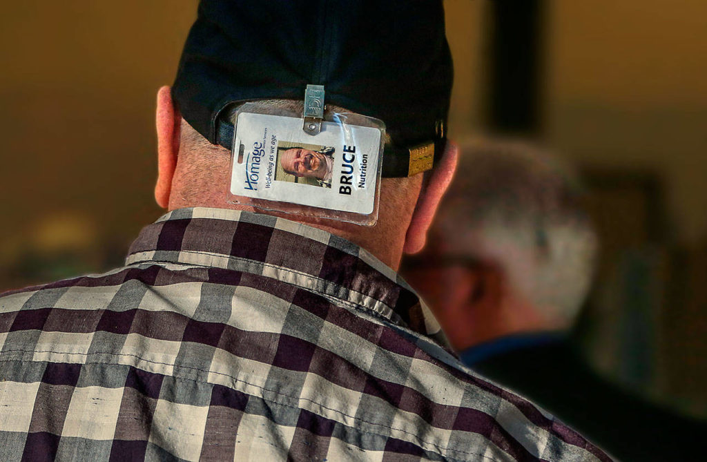 That’s using his head. Delivery driver Bruce Rhodes wears his photo ID where clients can easily see he is with Meals on Wheels. (Dan Bates / The Herald)
